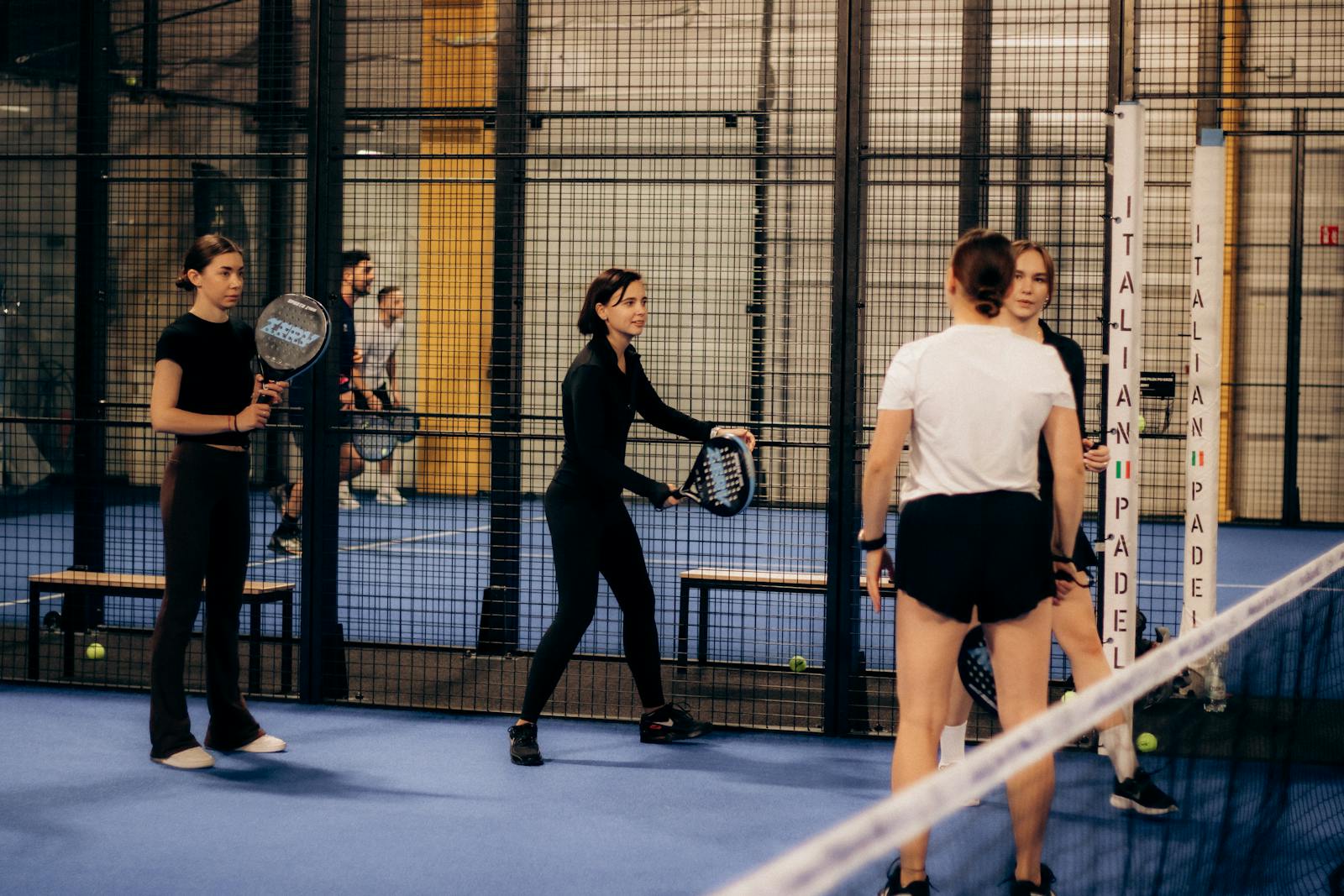 Four people playing padel on an indoor court